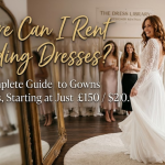 A happy bride twirling in a bohemian lace wedding dress inside a luxury rental boutique, next to a gold floor mirror and clothing racks, with friends smiling in the background. Integrated text reads, 'Where Can I Rent Wedding Dresses? Your Complete Guide to Gowns and Costs.'